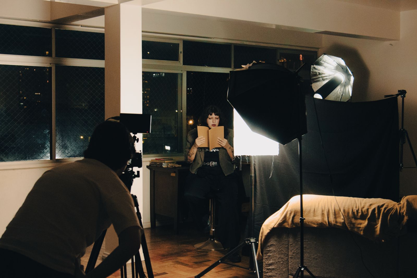 Bastidores da gravação dos vídeos de acessibilidade do projeto, com a artista Bill Or realizando a leitura de sua obra diante das câmeras e refletores de estúdio. Crédito: Mathý Odara Groszewica.
