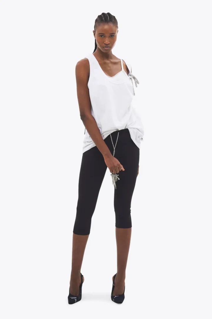 Capri preta, blusa branca e detalhes metálicos na coleção primavera/verão 2026 da AREA. (Foto: AREA/site oficial.)